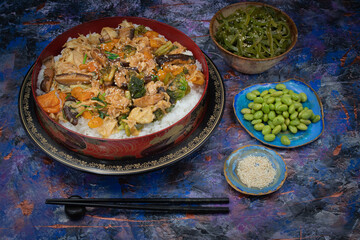 Vegan chirashizushi  made with yuba, shiitake, broccoli and pepper in traditional bowl along with wakame, edamame.