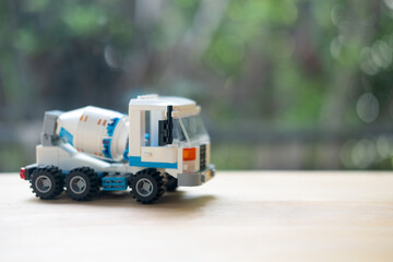 Concrete mixer truck plastic toy on wood table.