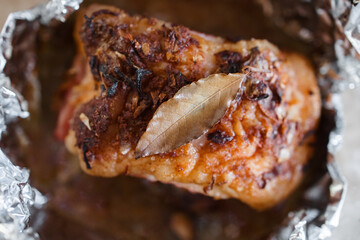baked pork with a crust with garlic and Bay leaf on foil