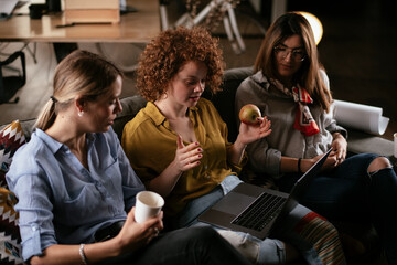 Girlfriends talking and laughing in office. Beautiful women drinking coffee in the office.