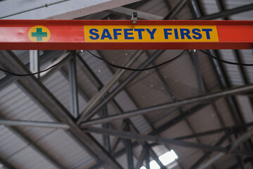 Safety first, yellow warning sign, On the crane In industrial plants backdrop