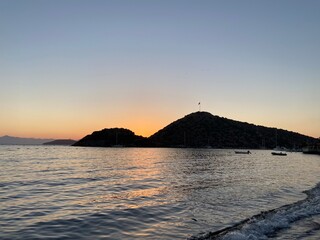 Fototapeta na wymiar Beautiful sea view at sunset, colorful at dawn, reflections on the sea, sun shades, lights and islands on the aegean sea. 