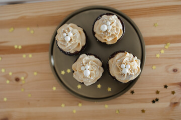 chocolate cupcakes with caramel cream decorated with silver on a gold tray