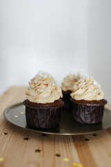 chocolate cupcakes with caramel cream decorated with silver on a gold tray