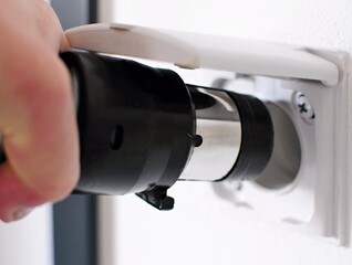 Plugging central vacuum cleaner in to wall inlet