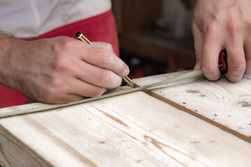 Fototapeta na wymiar Male carpenter working with wood material in a garage.