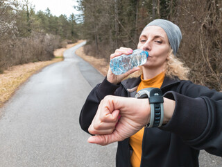 Adult caucasian woman in 40s exercising / jogging on a suburb road in winter / autumn season time.