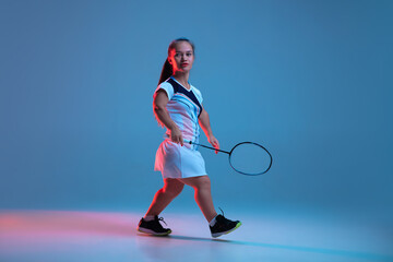 Winner. Beautiful dwarf woman practicing in badminton isolated on blue background in neon light. Lifestyle of inclusive people, diversity and equility. Sport, activity and movement. Copyspace.