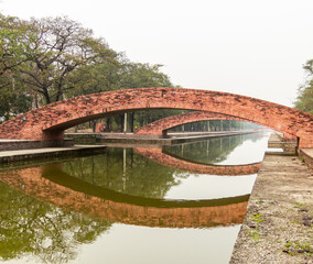 Modern bridges reflected in the waters of a canal in Lumbini