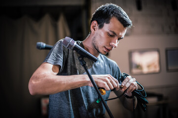 Theater audio technician adjusting an microphones on the scene. Installing and testing the sound...