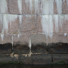 Square picture of old stone wall with white smudges in bright daylight for background or texture