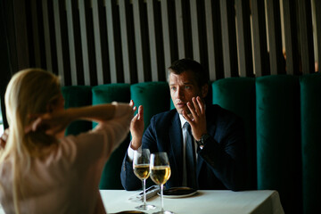 Handsome businessman dressed in the suit drinking wine. Businessman enjoying in the restaurant