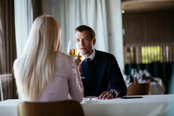 Handsome businessman dressed in the suit drinking wine. Businessman enjoying in the restaurant