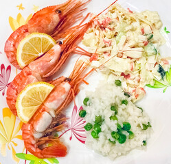 King prawns with fresh lemon slices and rice with vegetables. Dish with seafood in a plate. top view