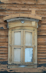 Fototapeta na wymiar old wooden window with closed shutters on the wall with scuffed paint. ancient, wooden architecture
