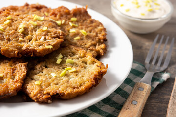 Traditional Jewish latkes or potato pancakes on wooden table