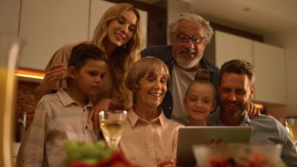 Family congratulating relatives at camera during video call. Family using pad
