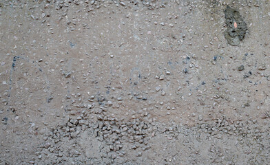 Texture of old reinforced concrete with protruding rusty rebar and moss