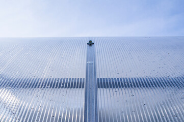 Steel hex bolt on the wall of a polycarbonate plastic greenhouse close up