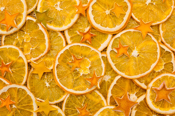 Orange stars made from dried Orange peel. Dried Orange slices on linen cloth. Christmas decoration. Advent ornaments. Ethnographic ornamentation background