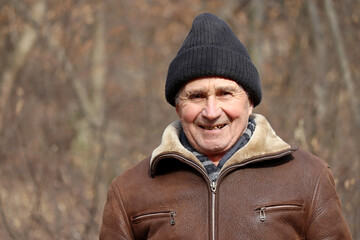 Portrait of happy elderly man outdoor. Autumn season, concept of old age, life in village - obrazy, fototapety, plakaty