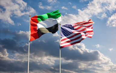 Flags of USA and UAE together against the sky background. Symbol of international relations between United States of America and United Arab Emirates.