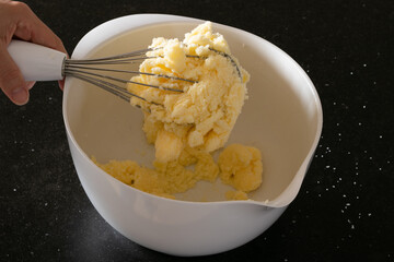 Whisking butter prepating cup cakes following a recipe