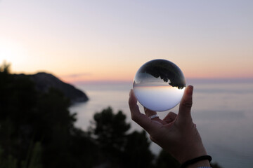 sunset over the sea inside a crystal ball.