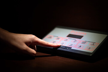 Action of person's finger is pressing on the "Night" button of master control box equipment, It's used to turn-off all lighting equipment in bedroom. Time to sleeping and smart life concept photo.