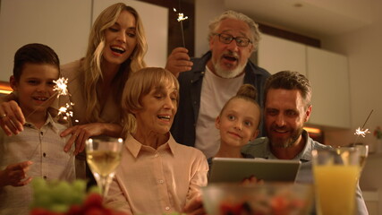 Positive family singing christmas song during online video chat on tablet