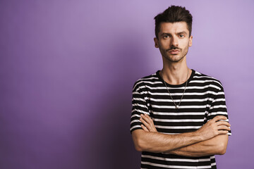 Fototapeta premium Photo of young handsome man posing with arms crossed on camera
