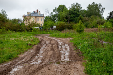 dirty clay mud road with puddles and tire tracks - closeup with selective focus and linear...