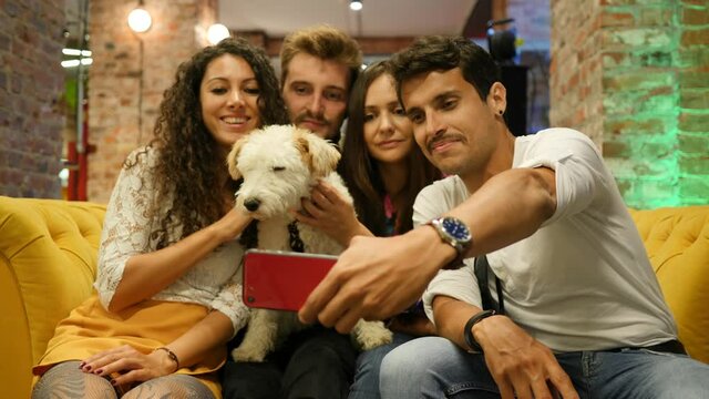 Friends with pet dog in bar take smartphone selfie picture hangout together having fun