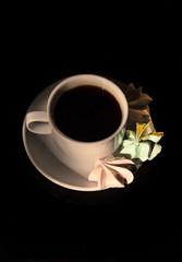 Retro a cup of coffee and a few meringues on black background. Minimalistic design for any purposes