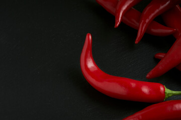Hot red pepper on a black stone plate in the background, raw food for the preparation of recipes...