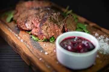 Close up tasty sliced roast beef served with salad on board.