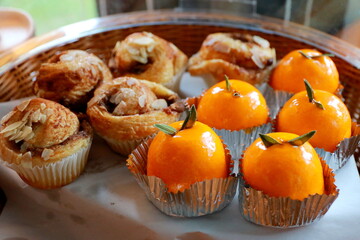 Orange cake and cup cake in basket for coffee break.