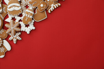 Different Christmas gingerbread cookies on red background, flat lay. Space for text