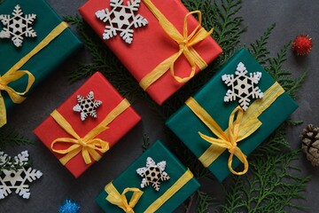 Colorful Christmas gifts on the background of christmas tree branches. Top view. Christmastime.