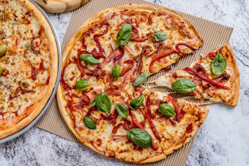 delicious homemade pizza with sauce, cheese ready to eat on white marble