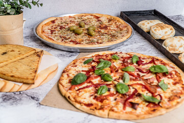 delicious homemade pizza with sauce, cheese ready to eat on white marble