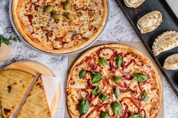 delicious homemade pizza with sauce, cheese ready to eat on white marble