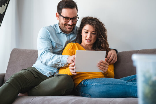 Portrait of smiling couple using tablet together at home stock photo
