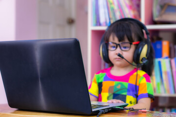 A 3 year old girl from ASEAN is studying online and chatting online.