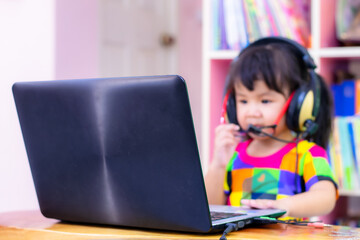 A 3 year old girl from ASEAN is studying online and chatting online.