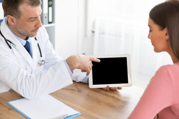 Obraz na płótnie Canvas Doctor showing patient digital tablet with black blank screen