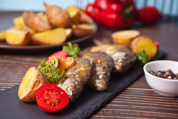 Grilled fish on plate with lemon and vegetables.