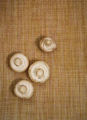 a handful of white mushrooms on a brown background with space for text