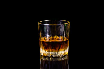 Glass of whiskey isolated on the black background