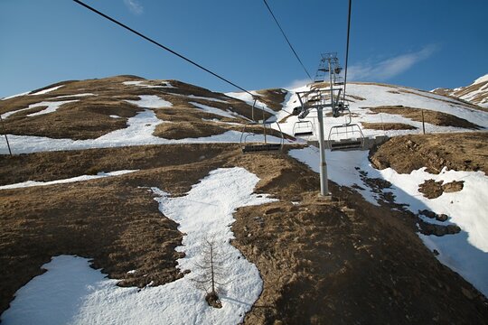 Ski lift in the Alps with lack of snow after heavy melting